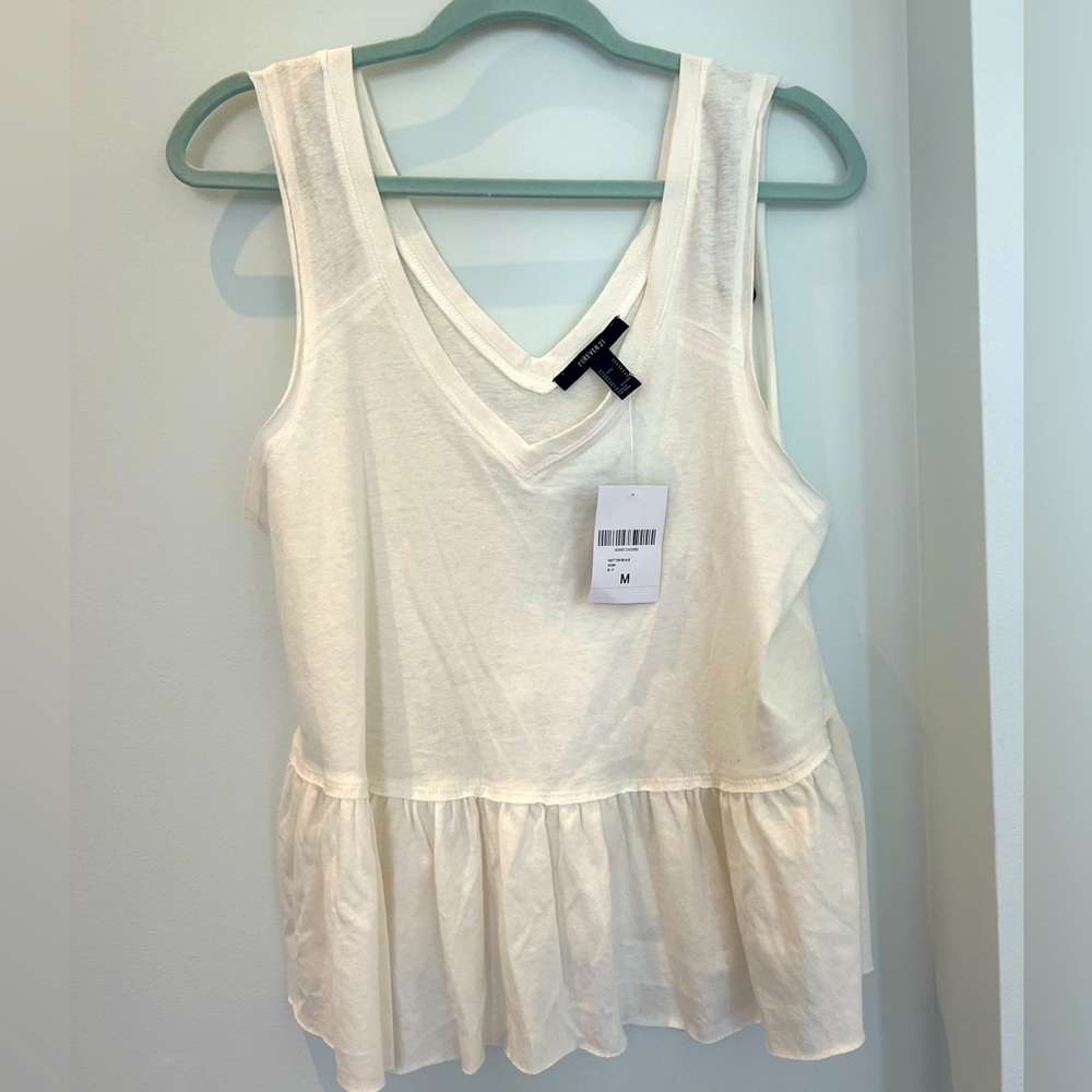 Forever 21 white v neck tank with ruffles on the bottom.